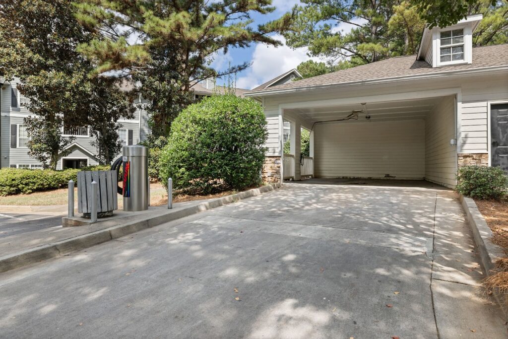 An empty residential carport with an attached outdoor vacuum station in the foreground.